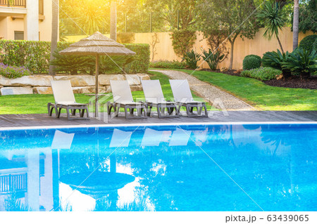 Pool with sun beds and umbrella for tourists at the hotel. Sunny day. 63439065