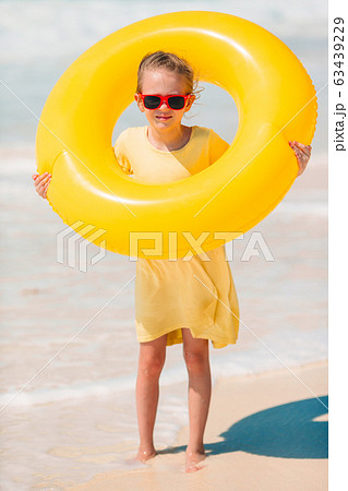 Adorable little girl having fun on the beach 63439229