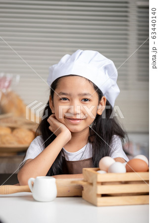 Asian little girl wearing a white chef hat and Asian little girl wearing a white chef hat and 63440140