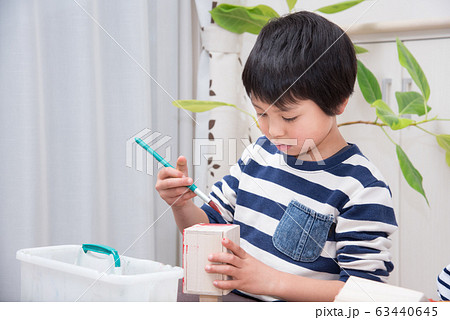 絵の具で作品に色を塗る小学生 63440645