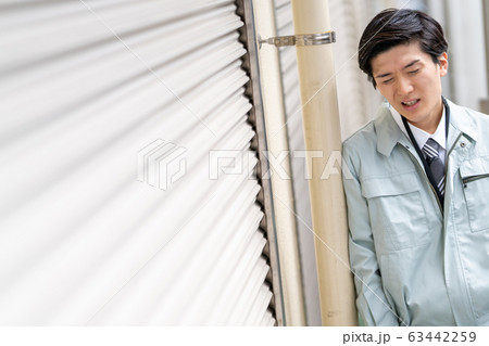 仕事が無くなり落ち込む作業服の男性ビジネスマン 63442259