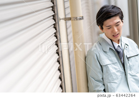 仕事が無くなり落ち込む男性 63442264