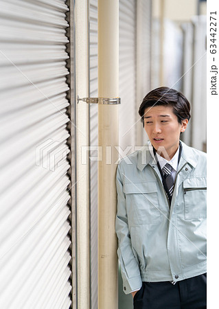 借金が膨らみ落ち込む作業服の男性ビジネスマン 借金が膨らみ落ち込む作業服の男性ビジネスマン 63442271