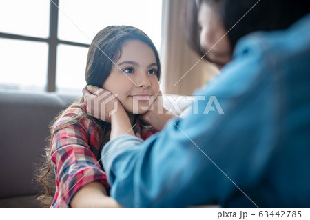 Mom touching her daughters face with tenderness Mom touching her daughters face with tenderness 63442785