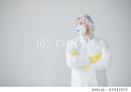 Man in protective suit, mask and glasses coughing, coronavirus pandemic threat. Man in protective suit, mask and glasses coughing, coronavirus pandemic threat. 63442825