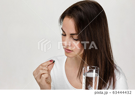 Sick woman taking pill painkiller medicine 63444432