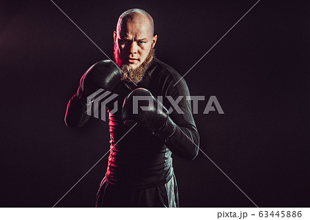Aggressive bearded boxer on dark background in studio 63445886