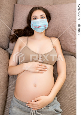 Young pregnant woman in protective medical mask  63447625