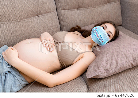 Young pregnant woman in protective medical mask Young pregnant woman in protective medical mask 63447626