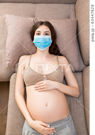 Young pregnant woman in protective medical mask  63447629