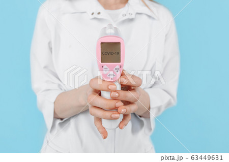 A female doctor in a protective mask measures the 63449631