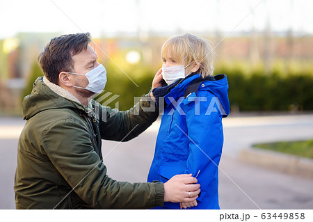 Mature man wearing a protective mask puts a face mask Mature man wearing a protective mask puts a face mask 63449858