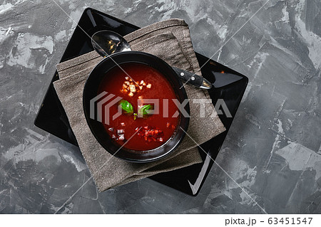 Tomato soup in a black bowl on a gray stone background. View from above. Copy space. Gray background. calm light. Food concept 63451547