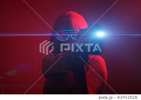 Girl with blaster in the futuristic battle. Concept virtual reality, cyber game. Girl with blaster in the futuristic battle. Concept virtual reality, cyber game. 63452026