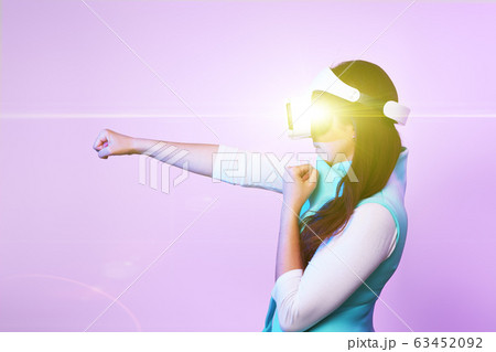 Woman is using virtual reality headset, playing game and fighting. 63452092