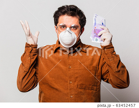 Style man in face mask and glasses holds money 63452457