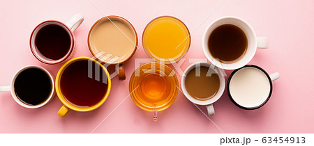 Mugs glasses with various traditional drinks coffee tea juice on pink background. Flat layout top view. Drinks concept. 63454913