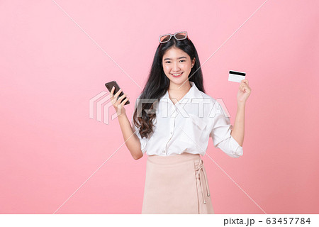 Young smiling Asian woman holding credit card. Young smiling Asian woman holding credit card. 63457784