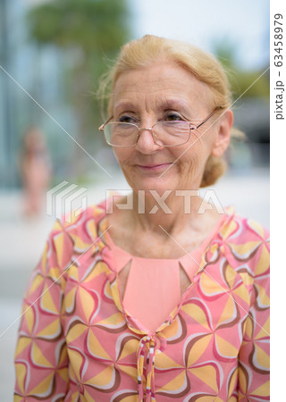 Beautiful senior tourist woman with blond hair relaxing around t 63458979
