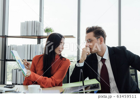 Two business people discussing about work in an Two business people discussing about work in an 63459511