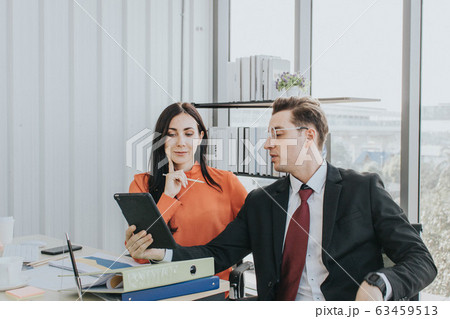 Two business people discussing about work in an 63459513