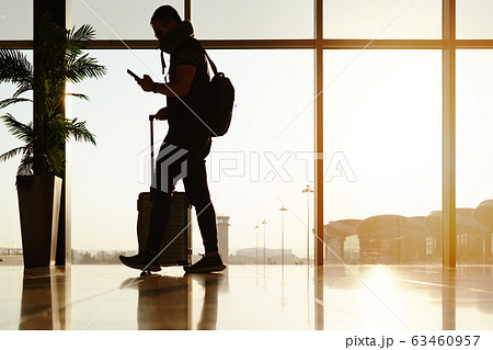 walking traveler with suitcase, passenger for tour in the airport terminal for air traveling 63460957