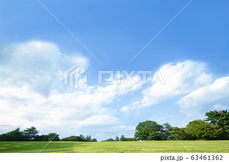 青空を背景にした無人の緑の丘 開放的 爽やか 自然イメージの背景素材の写真素材