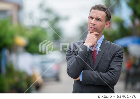 Businessman wearing suit in the streets outdoors Businessman wearing suit in the streets outdoors 63461776