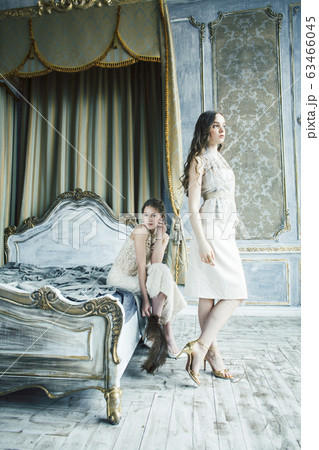 two pretty twin sister blond curly hairstyle girl in luxury house interior together, rich young people concept 63466045