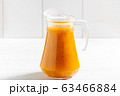 Glass jar of sea-buckthorn drink on wooden table 63466884