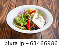 Plate of fresh greek salad on wooden table 63466986