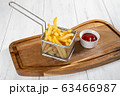 Basket of french fries with ketchup on wooden desk 63466987