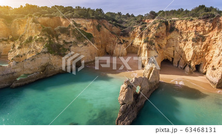 Aerial view of cliffs blue sea water beach Boiao, Portimao Portugal with sun 63468131