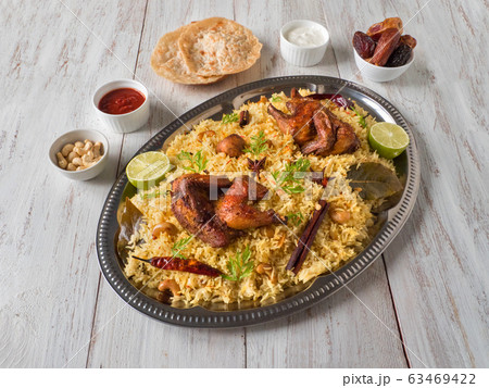 Chicken Mandi with dates on a wooden table.  63469422