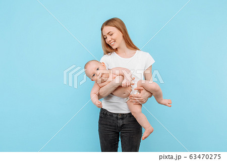Happy cheerful mom playing with her little baby on 63470275