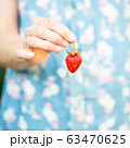 A woman holding a strawberry in her hand 63470625
