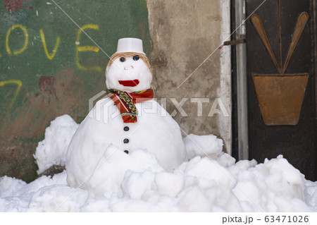 Snowman with scarf and hat stand alone at alley Snowman with scarf and hat stand alone at alley 63471026
