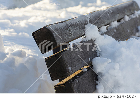 Snow-covered wooden bench in outdoor area after Snow-covered wooden bench in outdoor area after 63471027