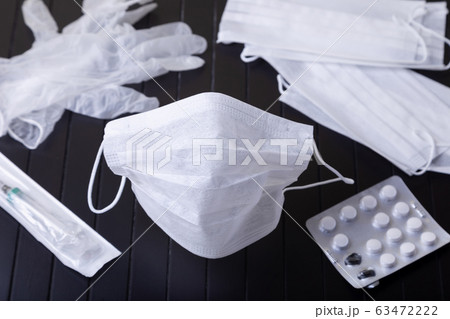 Medical white masks on a black background. Surgical protective mask against viruses and bacteria. The concept of protection against influenza, coronavirus, tonsillitis. Medical white masks on a black background. Surgical protective mask against viruses and bacteria. The concept of protection against influenza, coronavirus, tonsillitis. 63472222