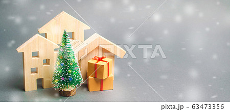 Wooden houses, Christmas tree and gifts. Holiday. Winter vacation. Christmas Sale of Real Estate. New Year discounts for buying housing. Purchase apartments at a low price. 63473356