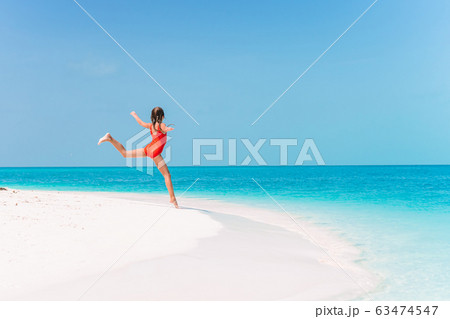 Adorable happy little girl have fun on beach vacation Adorable happy little girl have fun on beach vacation 63474547