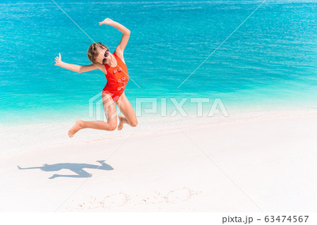 Adorable little girl have fun at tropical beach during vacation 63474567