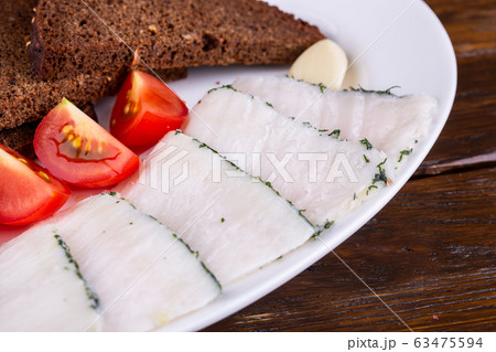Pieces of lard with greens, tomatoes and bread 63475594