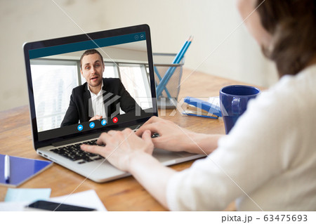 View over shoulder businesswoman listen applicant at distant job interview 63475693