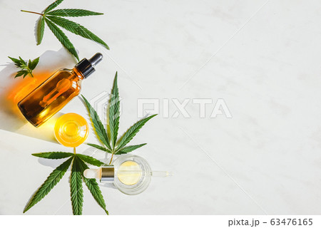 Glass brown bottle with cannabis CBD oil and marijuana leaves on a marble background. Copy space 63476165