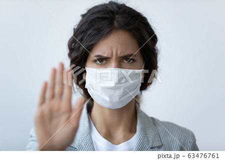 Woman in mask stretched arm as symbol of stop COVID19 63476761