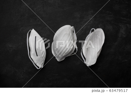 Anti coronavirus Covid-19 protective mask on dark background, horizontal Anti coronavirus Covid-19 protective mask on dark background, horizontal 63479517