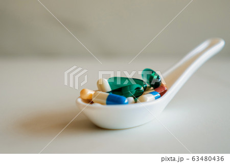Mixed of pill or tablet medicine on white spoon on Mixed of pill or tablet medicine on white spoon on 63480436