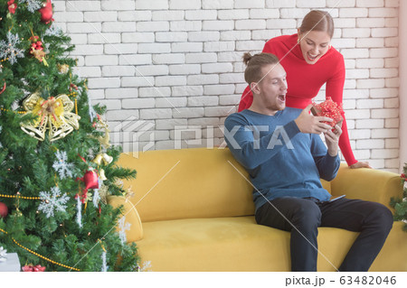 Caucasian couple. Woman giving gift to boyfriend.. 63482046