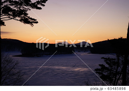 凍った岩洞湖から見える夕焼けの岩手山 63485898